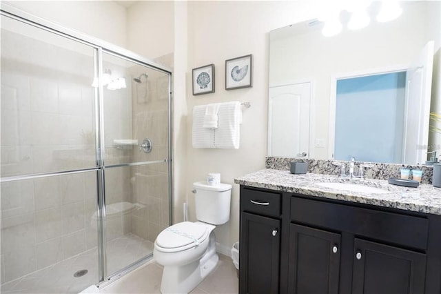 bathroom featuring tile patterned flooring, vanity, an enclosed shower, and toilet