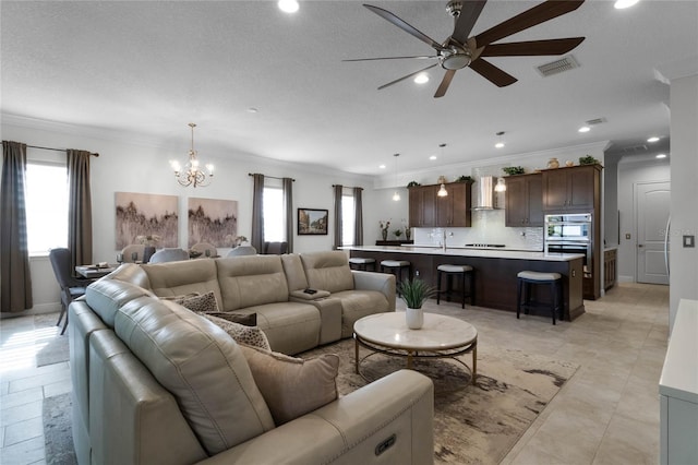 living room with ornamental molding and ceiling fan with notable chandelier