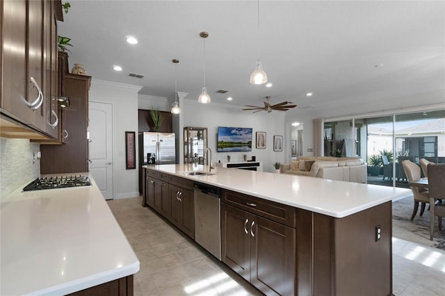 kitchen with a kitchen island with sink, sink, decorative light fixtures, and appliances with stainless steel finishes