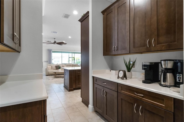 bar featuring ceiling fan, dark brown cabinets, and light tile patterned floors