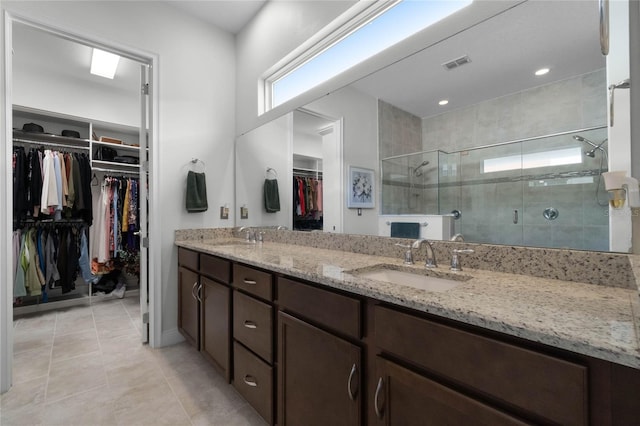 bathroom with tile patterned floors, vanity, and a shower with door