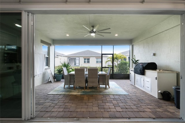 unfurnished sunroom featuring ceiling fan