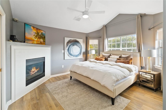 bedroom with ceiling fan, lofted ceiling, and light hardwood / wood-style floors