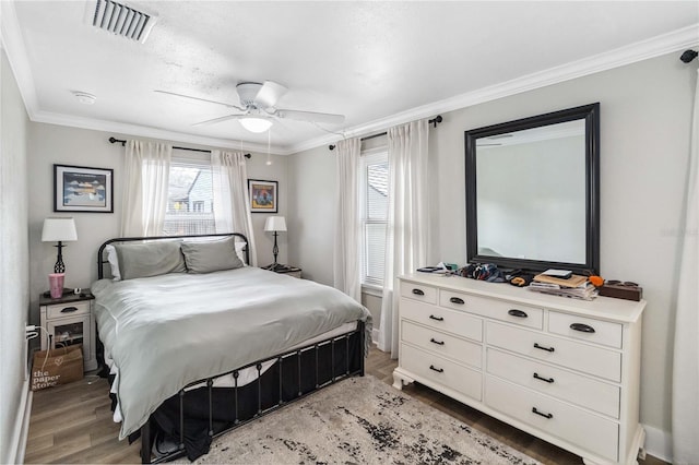 bedroom with ornamental molding, ceiling fan, and light wood-type flooring