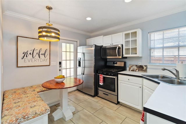 kitchen featuring white cabinetry, sink, hanging light fixtures, stainless steel appliances, and crown molding