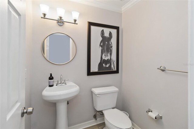 bathroom featuring ornamental molding and toilet