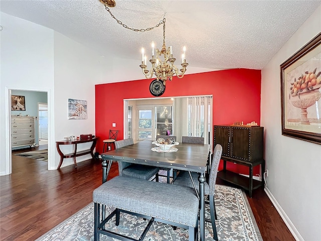 dining space featuring lofted ceiling, dark wood-type flooring, a textured ceiling, and an inviting chandelier