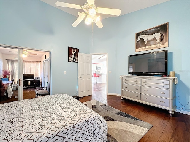 bedroom with hardwood / wood-style flooring, a towering ceiling, and ceiling fan