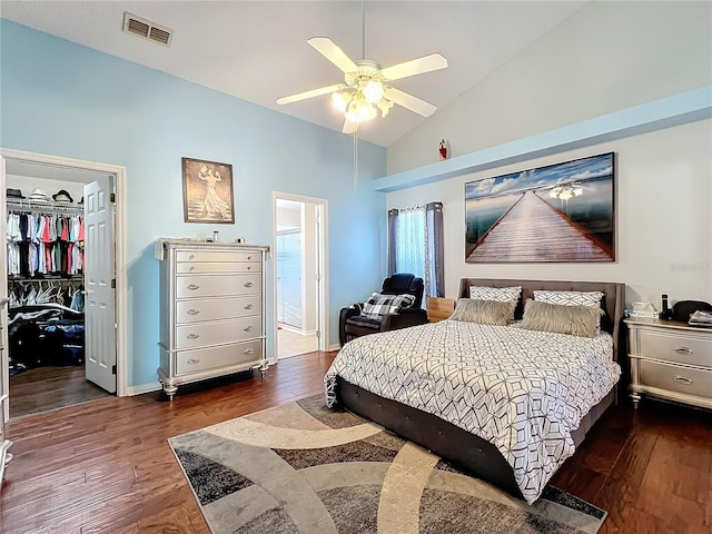 bedroom with lofted ceiling, a spacious closet, dark hardwood / wood-style floors, a closet, and ceiling fan