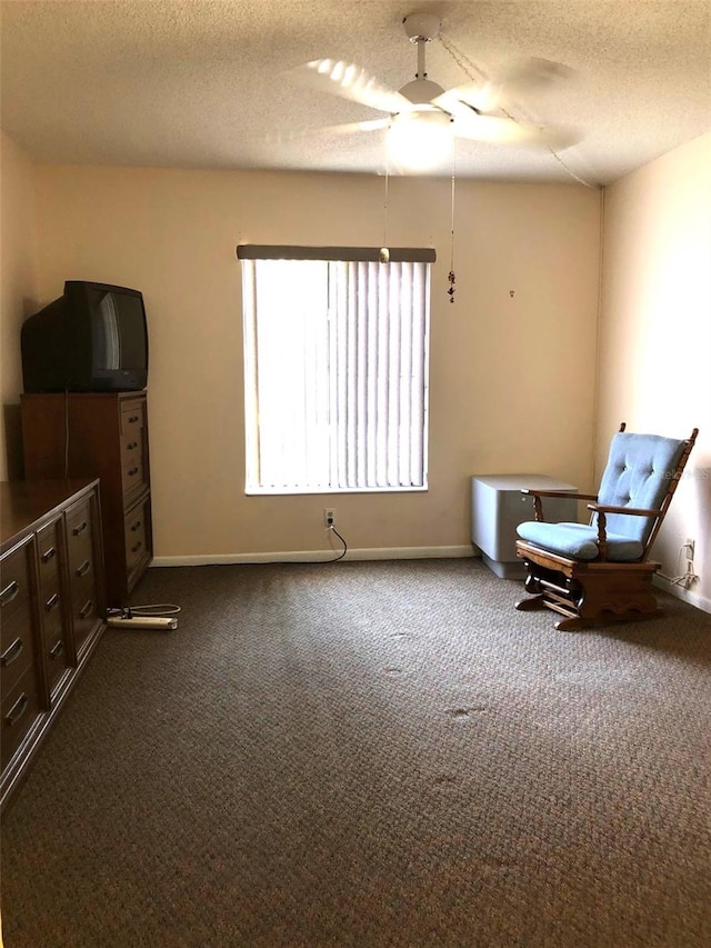 sitting room with ceiling fan, carpet, and a textured ceiling