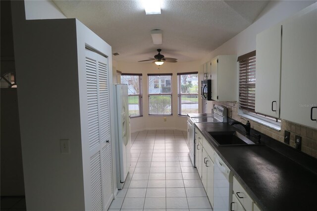 kitchen with sink, white appliances, light tile patterned floors, white cabinetry, and tasteful backsplash