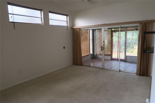 carpeted spare room with lofted ceiling and ceiling fan