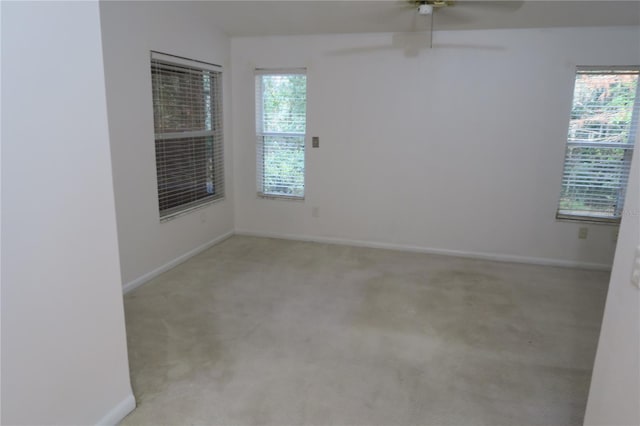 carpeted spare room featuring ceiling fan