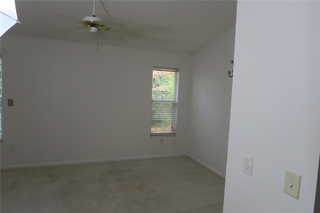 spare room with ceiling fan and light colored carpet