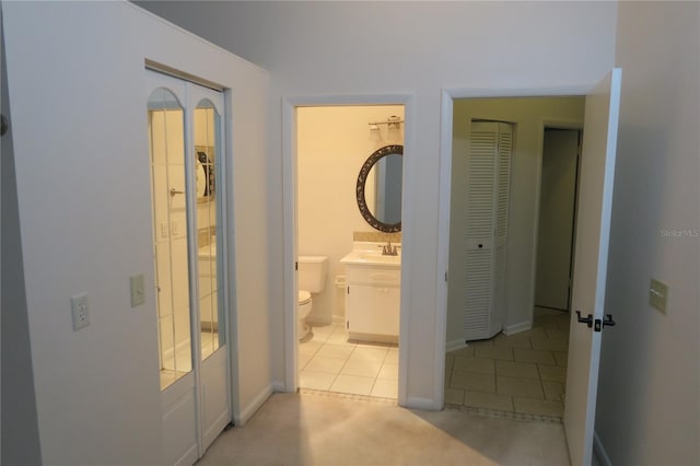 hall featuring light colored carpet and sink