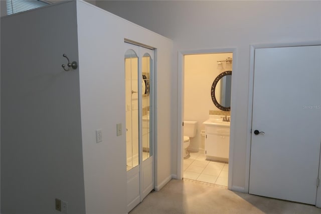 hallway featuring sink and light colored carpet