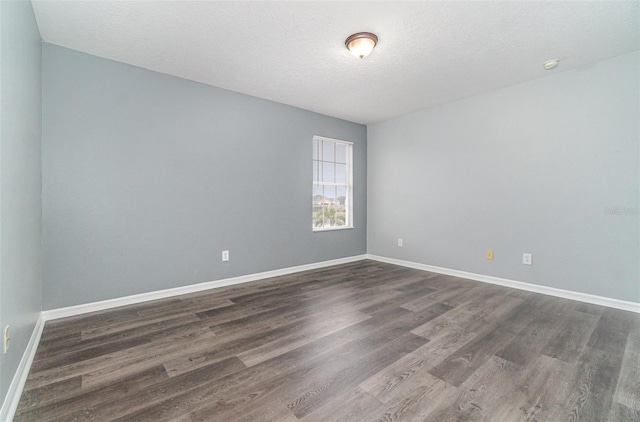 unfurnished room with dark hardwood / wood-style floors and a textured ceiling