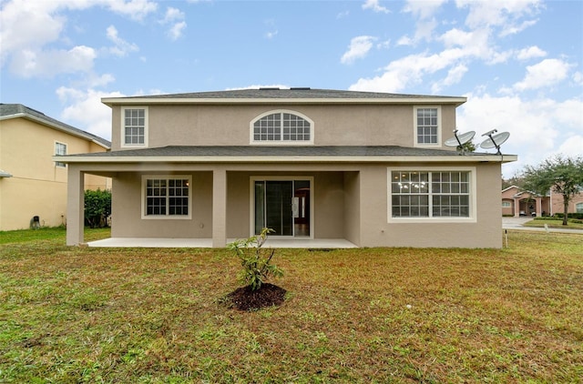 rear view of property featuring a patio area and a lawn