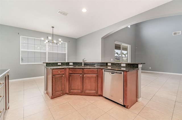 kitchen with sink, dishwasher, an island with sink, decorative light fixtures, and dark stone counters