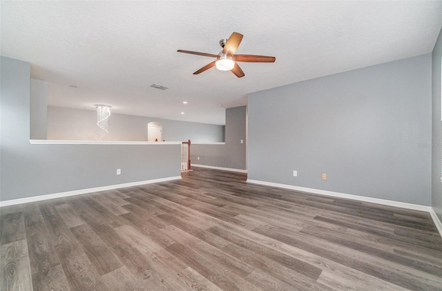 spare room with dark wood-type flooring, ceiling fan, and a textured ceiling