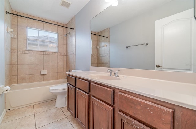 full bathroom featuring tiled shower / bath, vanity, toilet, and tile patterned flooring