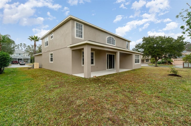 rear view of property featuring a patio area and a lawn