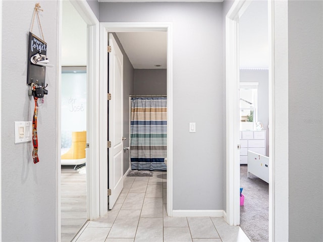 hall with light tile patterned floors