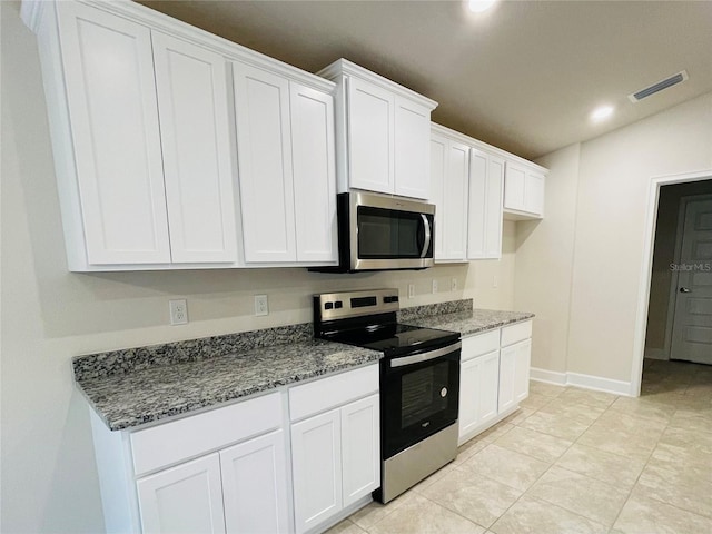 kitchen with white cabinetry, appliances with stainless steel finishes, and dark stone countertops