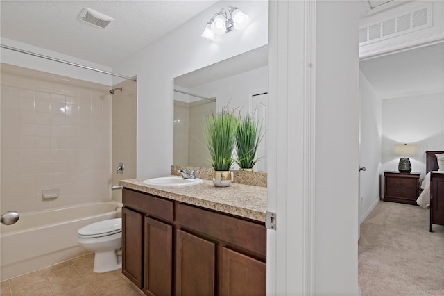 full bathroom with tile patterned floors, toilet, tiled shower / bath, a textured ceiling, and vanity