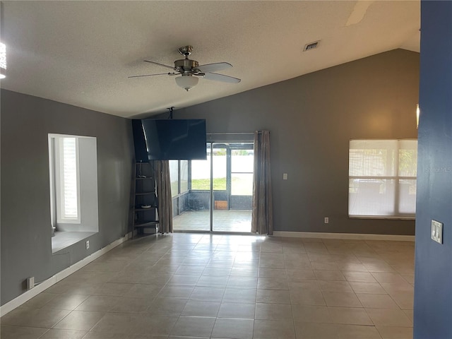 tiled spare room featuring lofted ceiling, a textured ceiling, and ceiling fan