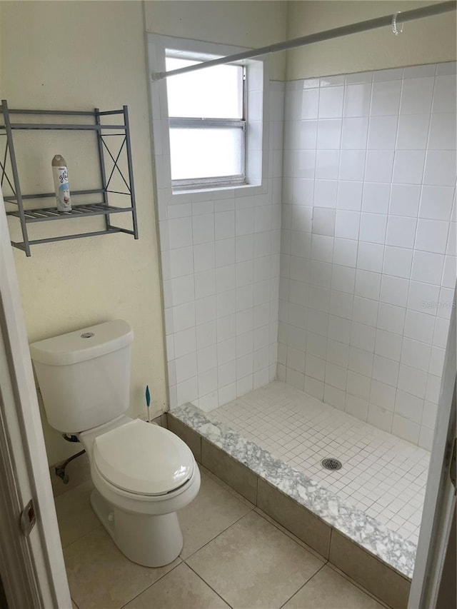 bathroom with tiled shower, tile patterned floors, and toilet