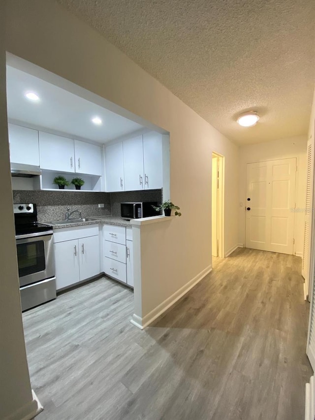 kitchen with white cabinets, range hood, light hardwood / wood-style flooring, and electric range