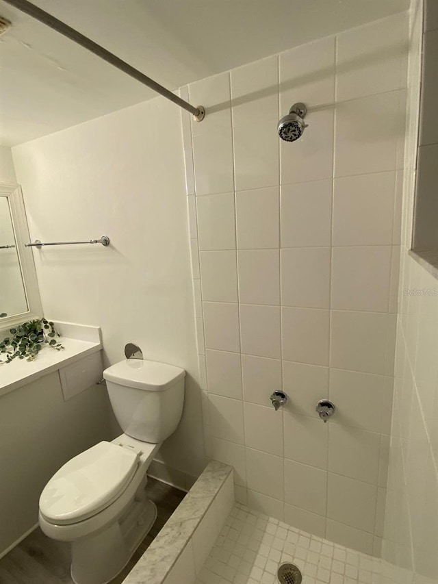 bathroom with toilet and tiled shower