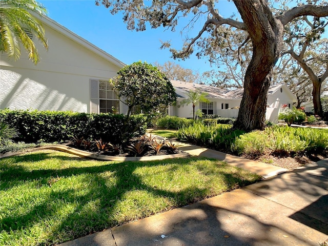 exterior space featuring stucco siding and a lawn