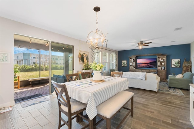 dining area featuring ceiling fan with notable chandelier