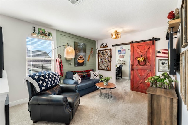 living room with light colored carpet, a barn door, and a textured ceiling