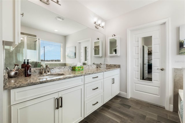 bathroom featuring vanity, wood-type flooring, and walk in shower