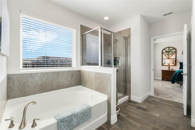 bathroom with hardwood / wood-style flooring and separate shower and tub