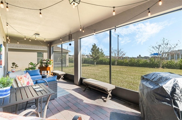 view of patio featuring a grill, an outdoor living space, and a sunroom