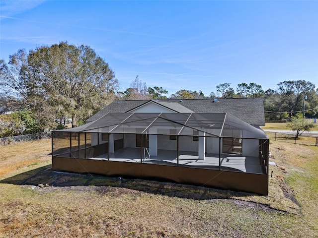 rear view of property featuring a patio, a lanai, and a yard