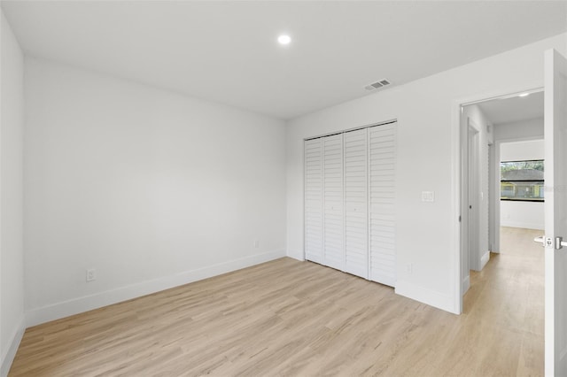 unfurnished bedroom with light hardwood / wood-style floors and a closet