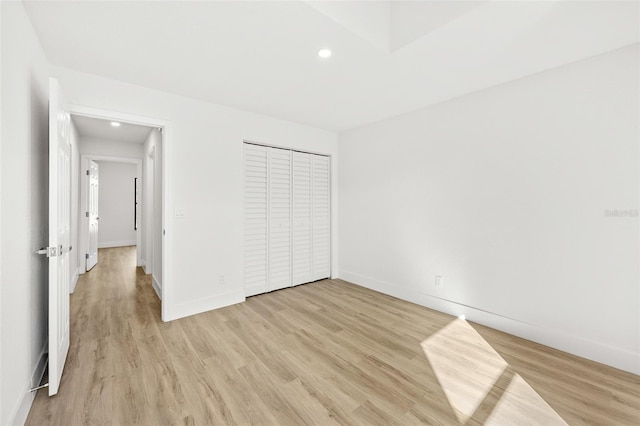 unfurnished bedroom with light wood-type flooring and a closet