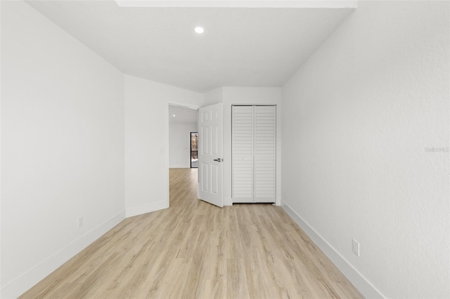 unfurnished bedroom with light hardwood / wood-style floors and a closet