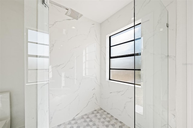 bathroom with toilet and a tile shower