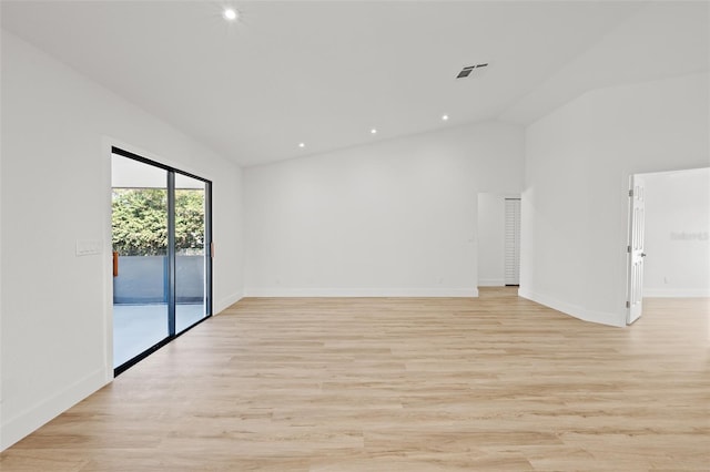 unfurnished room featuring lofted ceiling and light hardwood / wood-style flooring