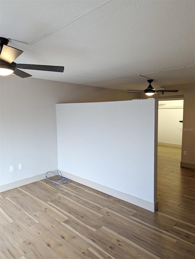 unfurnished room featuring ceiling fan, hardwood / wood-style floors, and a textured ceiling