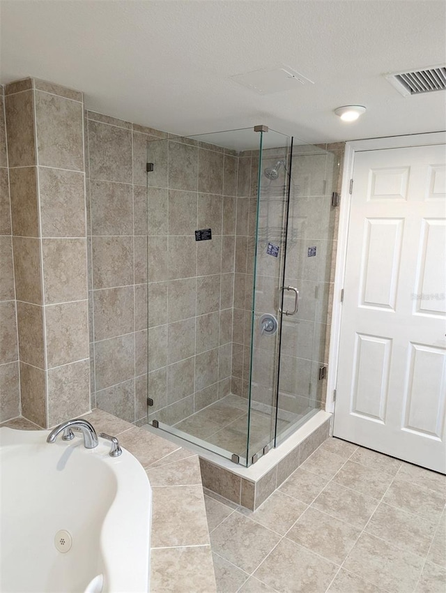 bathroom featuring tile patterned flooring and separate shower and tub