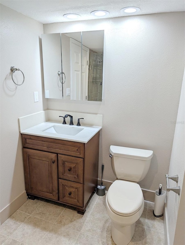 bathroom featuring vanity, tile patterned floors, and toilet