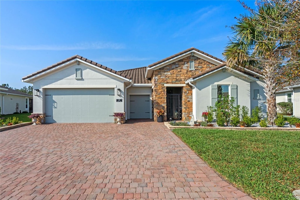 single story home with a garage and a front lawn