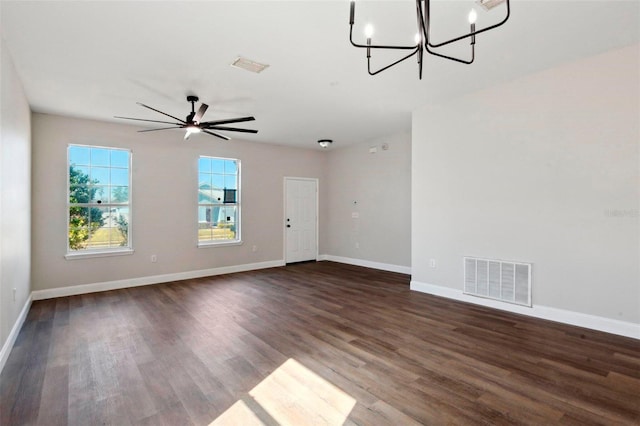 empty room featuring dark wood-type flooring and ceiling fan with notable chandelier